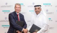 QEWC General Manager and Managing Director, Fahad bin Hamad Al Mohannadi (right), and Adrian Wood, Chief Executive Officer, Siemens Qatar, shaking hands after the signing ceremony.