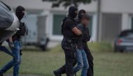 Police officers of a special unit escort Ali Bashar from a helicopter to the police headquarters in Wiesbaden western Germany, after he was flown back from Erbil to Germany AFP / dpa / Boris Roessler