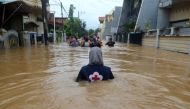 A volunteer wades through floods at a residential area in Makassar, South Sulawesi, Indonesia, January 23, 2019 in this photo taken by Antara Foto. Antara Foto/Sahrul Manda Tikupadang/ via REUTERS