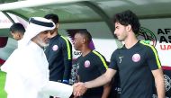Sheikh Hamad bin Khalifa bin Ahmed Al Thani, Qatar Football Association (QFA) President, shakes hands with Ahmed Alaaeldin during a practice session which took place in Abu Dhabi, yesterday.