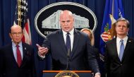 Acting Attorney General Matthew Whitaker speaks flanked by U.S. Commerce Secretary Wilbur Ross (L) and FBI Director Christopher Wray (R) during a news conference to announce indictments against China's Huawei Technologies Co Ltd, several of its subsidiari
