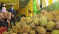 Indonesian customers sample durian fruits, which sell between 1.4 to 7 USD, at a stall in Medan on January 30, 2019. AFP / Rahmad Suryadi 