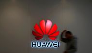 FILE PHOTO: A man walks by a Huawei logo at a shopping mall in Shanghai, China, Dec. 6, 2018. REUTERS/Aly Song/File Photo