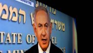 TV screen shows Israeli Prime Minister Benjamin Netanyahu delivering a speech on May 8, 2018. AFP/Thomas Coex