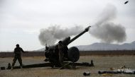 In this photo taken on February 2, 2019, an Afghan National Army (ANA) soldier fire a D30 122mm Howitzer gun as members of the NATO military forces (unseen) look on during a training session of ANA soldiers at Arena base in the Guzara district of Herat pr