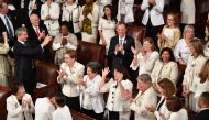 Congresswomen, dressed in white in tribute to the women's suffrage movement, applaud as they attend the State of the Union address at the US Capitol in Washington, DC, on February 5, 2019. / AFP / MANDEL NGAN