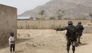 Cameroonian soldiers from the Rapid Intervention Brigade tell a young boy to stay back while on patrol in Kerawa, Cameroon, March 16, 2016. Joe Penney / Reuters