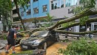 The owner looks at his car damaged by a fallen tree after a storm in Rio de Janeiro, Brazil, on February 7, 2019.  AFP / CDS / Carl De Souza  