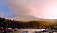 This picture taken at Pehe port on Siau island, Indonesia's North Sulawesi province shows Karangetang volcano spewing smoke on February 7, 2019.  AFP / Ungke Pepotoh