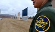 A US Border Patrol officer stands near prototypes of border wall proposed by US President Donald Trump on November 1, 2017 in San Diego, California. AFP/Frederic J Brown