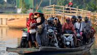 Motorists are being transported on a raft as they cross a river in Jakarta, Indonesia, February 14, 2019. Reuters/Willy Kurniawan