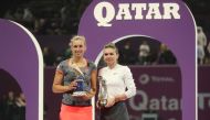 Belgian Elise Mertens and Romanian Simona Halep pose with their trophies at the end of their WTA Qatar Open final tennis match in Doha on February 16, 2019. / AFP / KARIM JAAFAR
