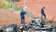 Indian Air Force (IAF) personnel gather around the wreckage of one Surya Kiran 'Hawk' aircraft after two of them collided in mid-air and crashed during India's biennial international Air Show rehearsal at the Yelahanka Air Force Station in Bangalore on Fe