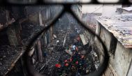 Firefighters are seen at the scene of a fire in Dhaka on February 21, 2019. AFP / Munir UZ ZAMAN