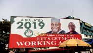 A billboard with a campaign poster bearing images of the opposition Peoples Democratic Party election candidate Atiku Abubakar and his running mate Peter Obi stands on a road in Abuja on February 19, 2019, ahead of rescheduled general elections. AFP / Piu