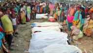 People stand next to the bodies of tea plantation workers, who died after consuming bootleg liquor, in Golaghat in the northeastern state of Assam, India, February 22, 2019. Reuters 