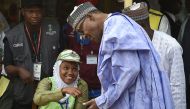 Candidate of the All Progressives Congress (APC) and incumbent President Muhammadu Buhari (R) verifies his card to vote at a polling station in his native hometown Daura in Katsina State, northwest Nigeria, on February 23, 2019. (AFP / PIUS UTOMI EKPEI)