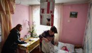 An elderly woman immobilised in bed is helped to vote by a relative in a mobile ballot box in Bardar village, on February 24, 2019, as Moldovans are called to the polls to elect new parliament members.  AFP / Daniel Mihailescu 