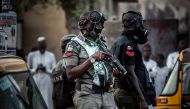 Nigerian police wearing gas masks monitor an area where All Progressives Congress Party (APC) supporters celebrate initial results released by the Nigerian Independent National Electoral Commission (INEC) in Kano, on February 25, 2019, two days after gene