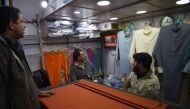 Pakistani tailors watch a television broadcasting breaking news in Islamabad on February 27, 2019. AFP / FAROOQ NAEEM
 