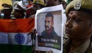 Indian security forces pose with the national flag and pictures of Indian Air Force pilot Abhinandan Varthaman during an event to pray for his return, at Kalikambal temple in Chennai on March 1, 2019.  AFP / Arun Sankar 