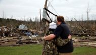 A man hugs Julie Morrison while looking at the remains of her home following a string of tornadoes that resulted in several fatalities in Beauregard, Alabama, U.S., March 4, 2019. REUTERS/Elijah Nouvelage