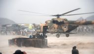 An Afghan military helicopter rescues people from atop an overturned truck in flooded area of Arghandab district in Kandahar province.  AFP / JAVED TANVEER

