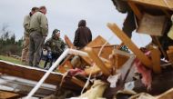 Julie Morrison (C), sits on a salvaged chair, surrounded by friends, as she looks at the wreckage of her home after two deadly back-to-back tornadoes, in Beauregard, Alabama,  March 4, 2019. Reuters/Elijah Nouvelage