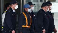  In this file photo taken on March 6, 2019, former Nissan chairman Carlos Ghosn (C-light blue cap) is escorted as he walks out of the Tokyo Detention House following his release on bail in Tokyo. / AFP / Behrouz MEHRI
 