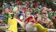 A worker removes labels from recycled plastic bottles to be used in the construction of the sailboat Plastiki at Pier 31 in San Francisco, March 13, 2009. Reuters/Robert Galbraith
