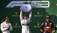 Mercedes' Finnish driver Valtteri Bottas (C) celebrates with the trophy next to second-placed Mercedes' British driver Lewis Hamilton (L) and third-placed Red Bull Racing's Dutch driver Max Verstappen (R) on the podium after the Formula One Australian Gra