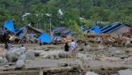People stand as they look at damaged houses after a flash flood in Sentani, Papua, Indonesia, March 17, 2019 in this photo taken by Antara Foto. Antara Foto/Gusti Tanati/ via REUTERS 
