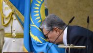 Acting President of Kazakhstan Kassym-Jomart Tokayev kisses a flag as he takes part in a swearing-in ceremony during a joint session of the houses of parliament in Astana, Kazakhstan March 20, 2019. 	
