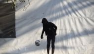 A Central American migrant taking part in a caravan towards the US plays with a ball at a stadium-turned-shelter during a stop in the journey in Mexico City on November 7, 2018. AFP/Alfredo Estrella