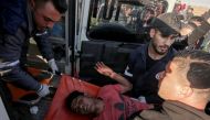 Palestinian paramedics carry an injured protester at the border fence with Israel east of Gaza City on March 22, 2019. AFP / Said Khatib 
