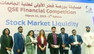 Rashid bin Ali Al-Mansoori, CEO of Qatar Stock Exchange, with students who participated in the competition.