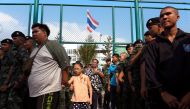 Civilians walk by as soldiers line up to vote in the general election at a polling station in Bangkok, Thailand March 24, 2019. REUTERS/Cory Wright