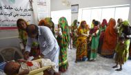 In this picture taken on May 25, 2018, a Pakistani paramedic weighs a child at Mithi Civil Hospital in Mithi, a remote town in southern Pakistan. AFP /Rizwan Tabassum