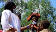 A Congolese health worker checks the temperature of a child before vaccination against the deadly Ebola virus near Mangina village, DR Congo, August 8, 2018. Reuters/Samuel Mambo