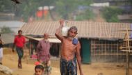 A Rohingya man walks through the mud along with a kid as they take shelter at a makeshift camp in Coxs' Bazar, Bangladesh on September 24, 2017. Zakir Hossain Chowdhury / Anadolu Agency