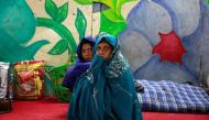 Women wrap themselves in blankets in a government shelter for homeless people to escape the cold in Delhi, India January 16, 2017. Reuters/Cathal McNaughton
