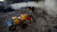 A boy pushes a wheelbarrow filled with water containers after collecting drinking water from a charity tap amid a cholera outbreak in Sanaa, Yemen, October 13, 2017. Reuters/Mohamed al-Sayaghi