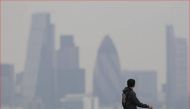 A man walks through Greenwich Park as a haze of pollution sits over the London skyline April 3, 2014. Reuters/Luke MacGregor
