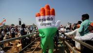 A supporter wearing an inflatable symbol of India's main opposition Congress party walks during a public meeting in Gandhinagar, Gujarat, India, March 12, 2019. The words read: 