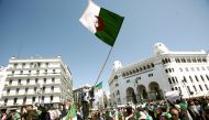 People carry national flags during a protest to demand the removal of President Abdelaziz Bouteflika in Algiers, Algeria March 29, 2019. Reuters/Ramzi Boudina 