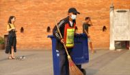 A man wears mask as he sweeps the ground near a palace in Chiang Mai, Thailand April 3, 2019. Reuters/Soe Zeya Tun