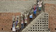 Indian labourers carry clay bricks to a brick kiln in Farakka, in the Indian state of West Bengal, on March 3, 2019.  AFP / Xavier Galiana 
 