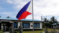 FILE PHOTO: Filipino soldiers stand at attention near a Philippine flag at Thitu island in disputed South China Sea April 21, 2017. REUTERS/Erik De Castro