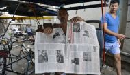 A man shows a two-sheet edition of Cuban official newspaper Granma on his bicitaxi in Havana, on April 5, 2019. AFP / YAMIL LAGE