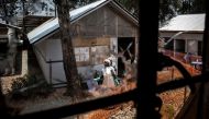 In this file photo taken on March 9, 2019 health workers are seen through a bullet hole left in the window of an Ebola treatment centre, which was attacked in the early hours of the morning in Butembo. AFP / John Wessels
 